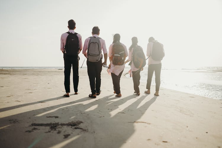 Group Of People Walking On Beach