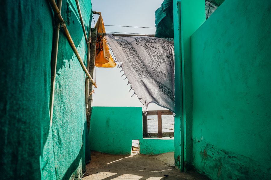 Colorful outdoor scene with hanging cloth in a seaside alley in Goa, India.