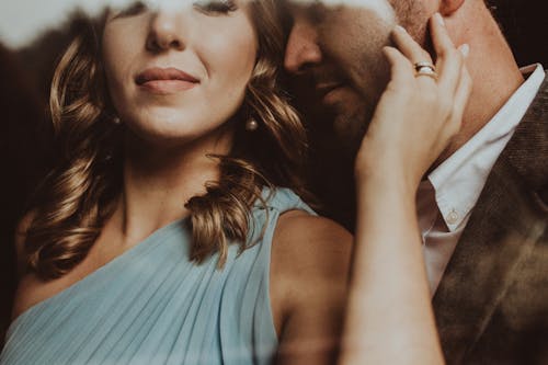Crop elegant ethnic woman embracing male beloved