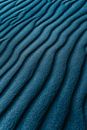 From above of bright texture of sand putting wavily on area like dune in windy weather