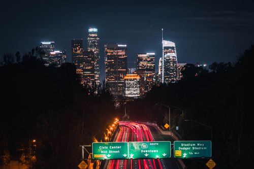 Free Long exposure of Los Angeles city skyline at night, capturing vibrant city lights and highway traffic trails. Stock Photo