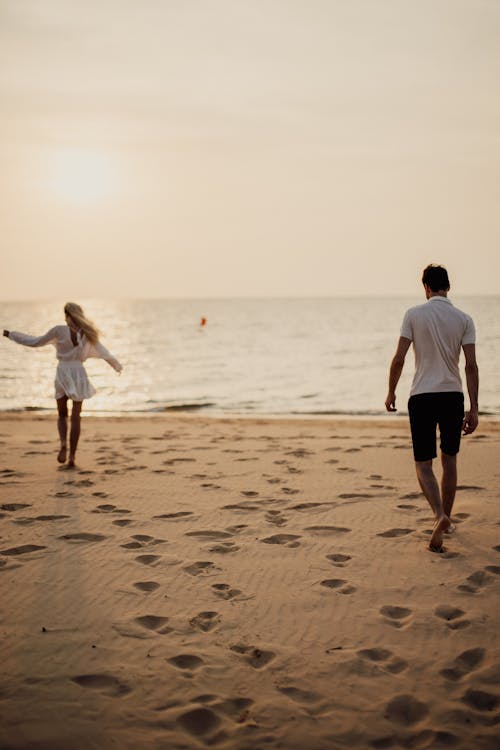 Hombre Y Mujer Caminando En La Playa