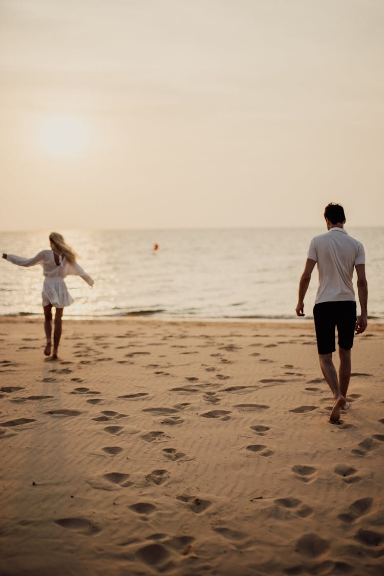 Man And Woman Walking On Beach