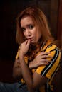 Sensitive ethnic woman in striped t shirt on black background