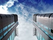 低角度视角下，未来主义摩天大楼矗立在充满活力的多云天空下