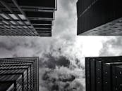 以单色拍摄的高层摩天大楼和多云天空的低角度镜头