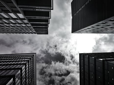 以单色拍摄的高层摩天大楼和多云天空的低角度镜头