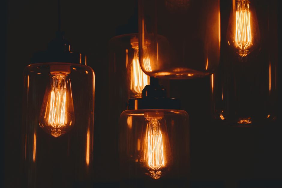 Myth-Busting Smart Bulbs vs Smart Switches: What Works Best in 2026 Close-up of vintage light bulbs with exposed filaments, glowing warmly against a dark background.