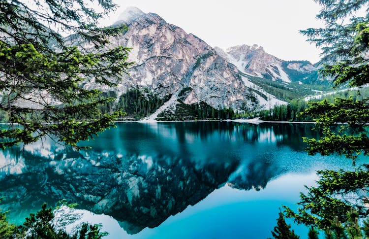 Lake And Mountain Under White Sky