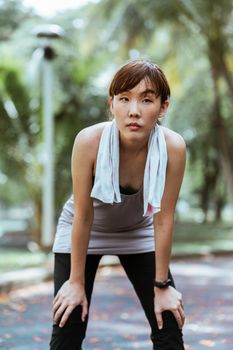 一名年轻女子在宁静的公园锻炼后休息