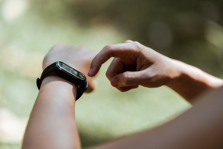 Crop Unrecognizable Person Using Smart Watch Outdoors