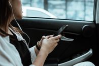一名女子一边开车，一边听音乐、用手机，享受休闲时光