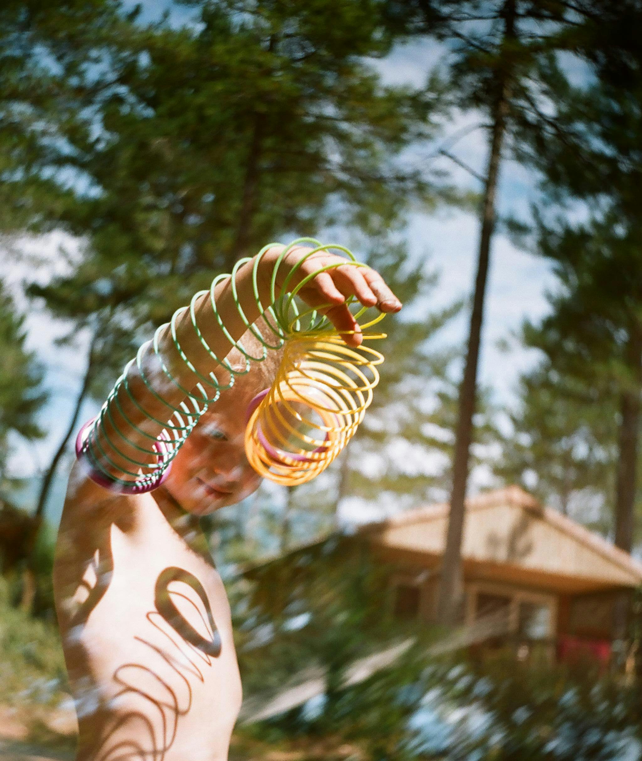 Young boy enjoying a colorful rainbow toy outdoors in Bédoin, France during spring.