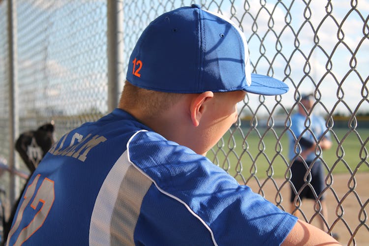  A Boy In Blue And White Baseball Jersey Shirt And Blue Baseball Cap