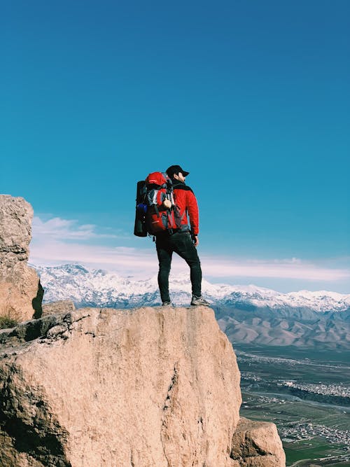 Backpacker Standing on the Top of a Mountain 