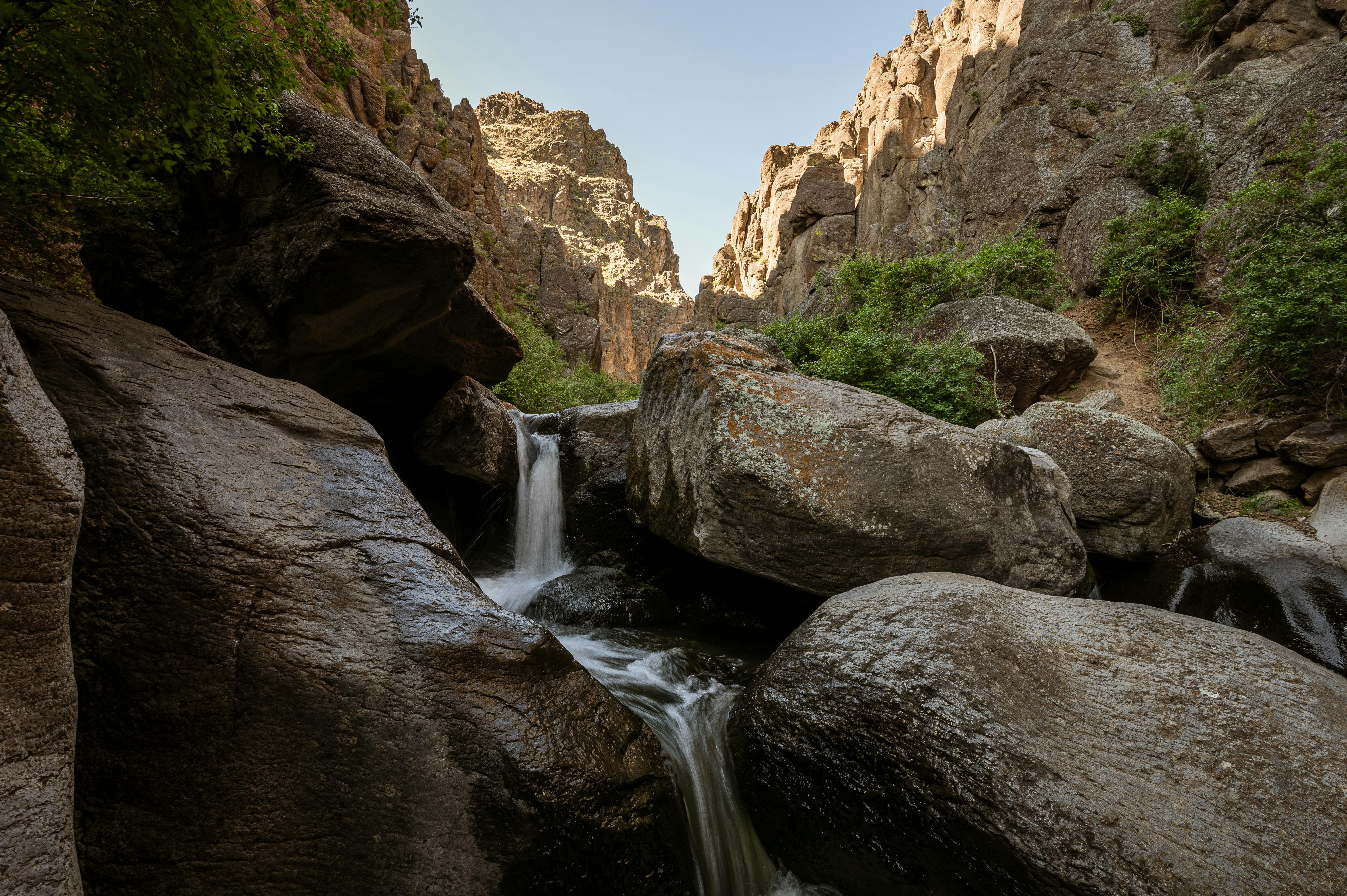 Rocky ravine with waterfall flowing through