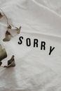 Word Sorry on White Fabric
