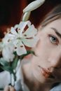 Calm young lady enjoying smell of white lilies