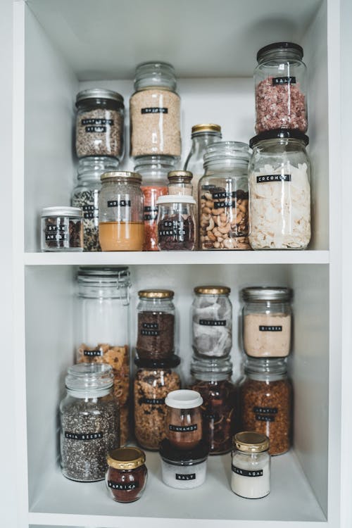 Clear Glass Jars on White Wooden Shelf