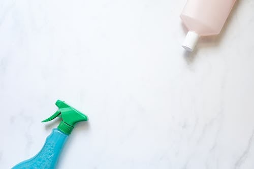 Spray Bottle Beside a Bottle of Cleaning Product