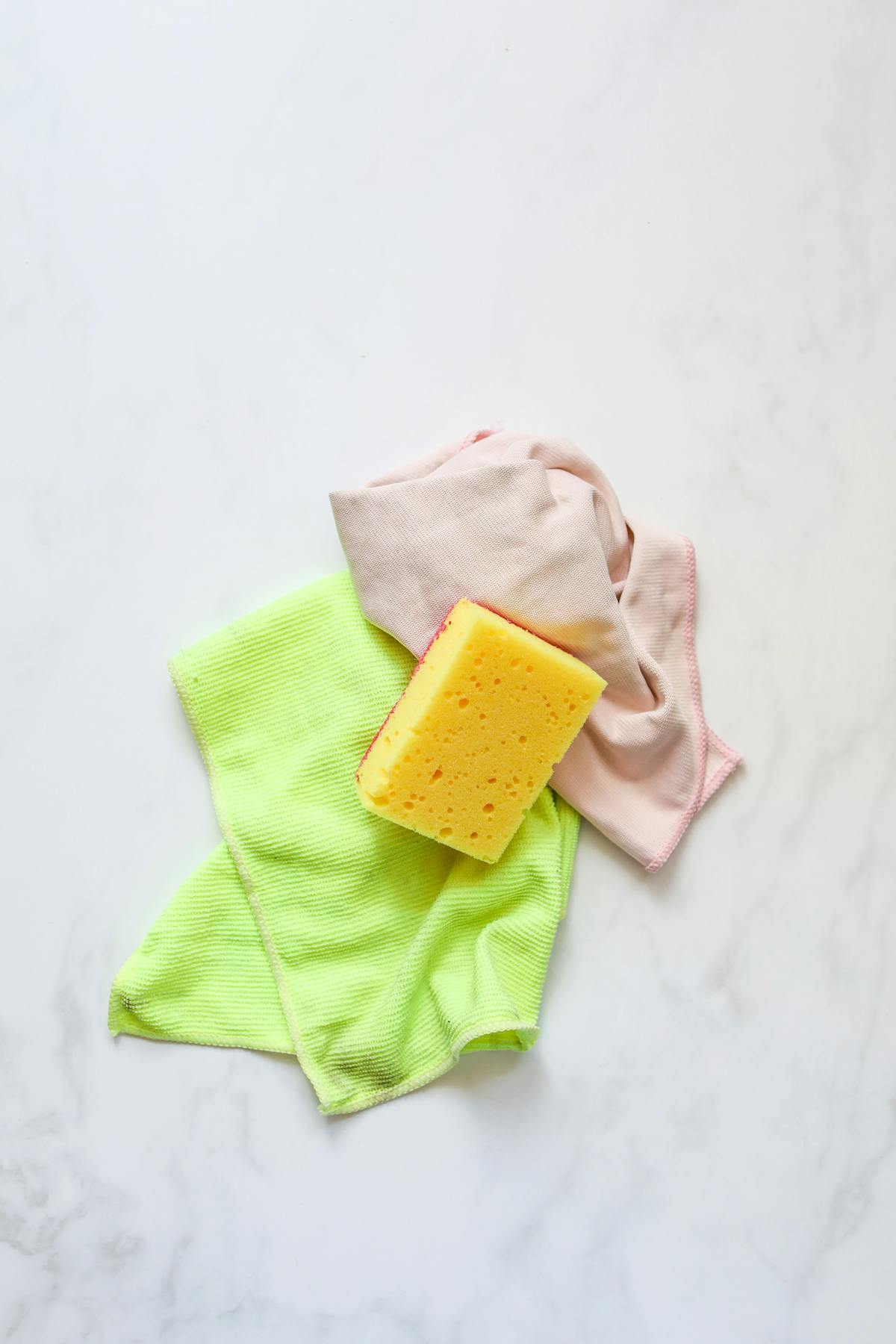 Spugna gialla appoggiata su panno in microfibra pulito