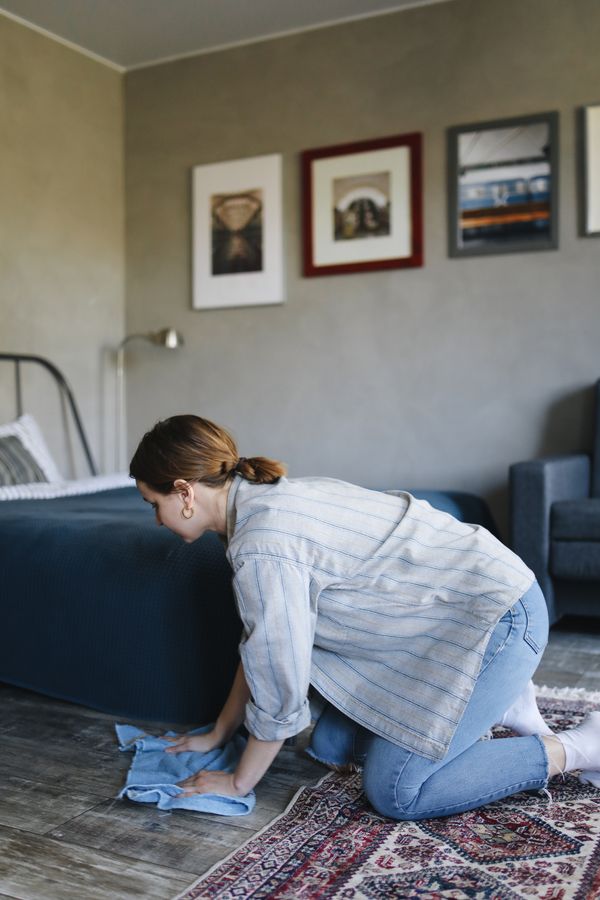 Person blotting a spill on a bedroom carpet with a cloth