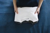 Neatly Folded White Crew Neck T-shirt Over Other Shirts