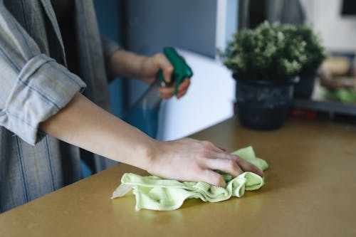 Free A Person Cleaning the Table with Cleaning Cloth Stock Photo
