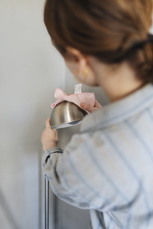 Free A Woman Wiping the Stainless Lamp with Cloth Stock Photo