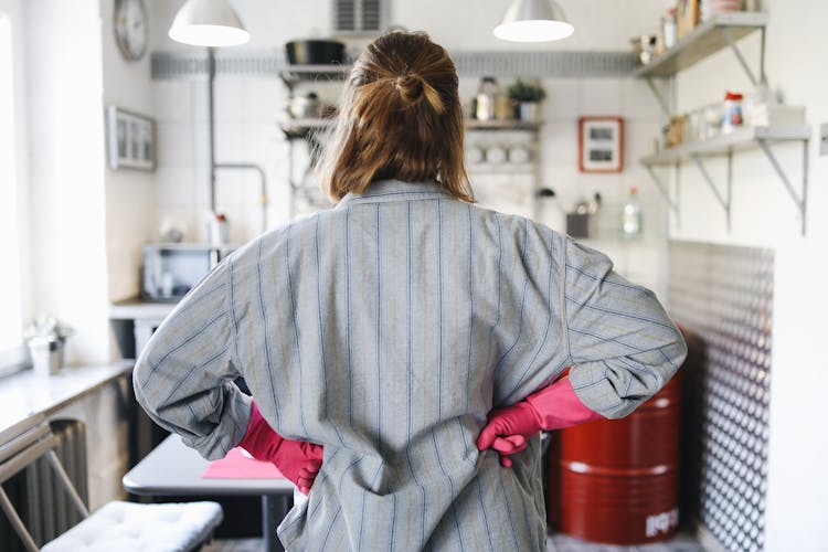 A Person Wearing Pink Rubber Gloves With Hands On Waist