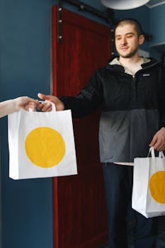 Man receiving a delivery bag with a yellow circle design at the doorstep.