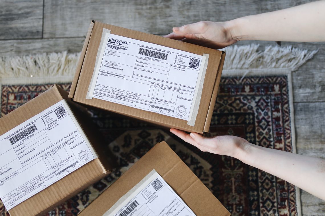 Hands holding labeled cardboard packages for exchange