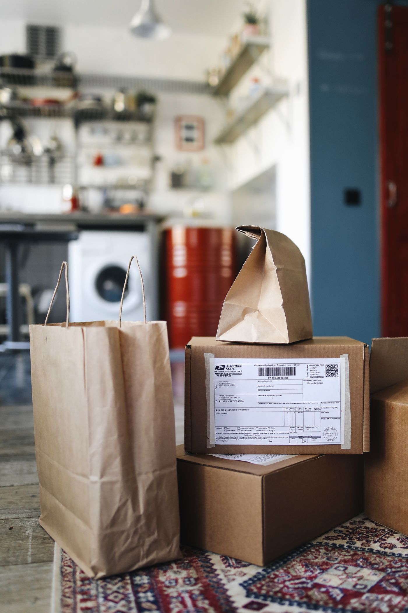 Cardboard delivery boxes and shopping bags arranged inside a contemporary home kitchen