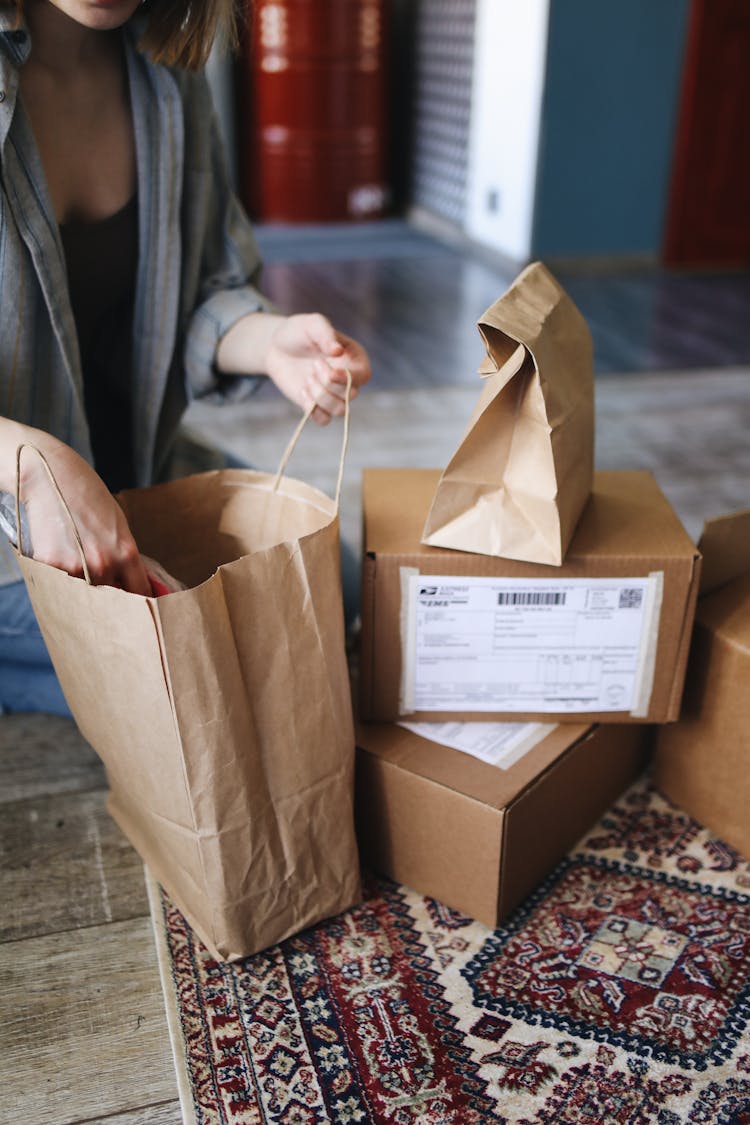 Woman Unpacking Shopping Bags And Parcels