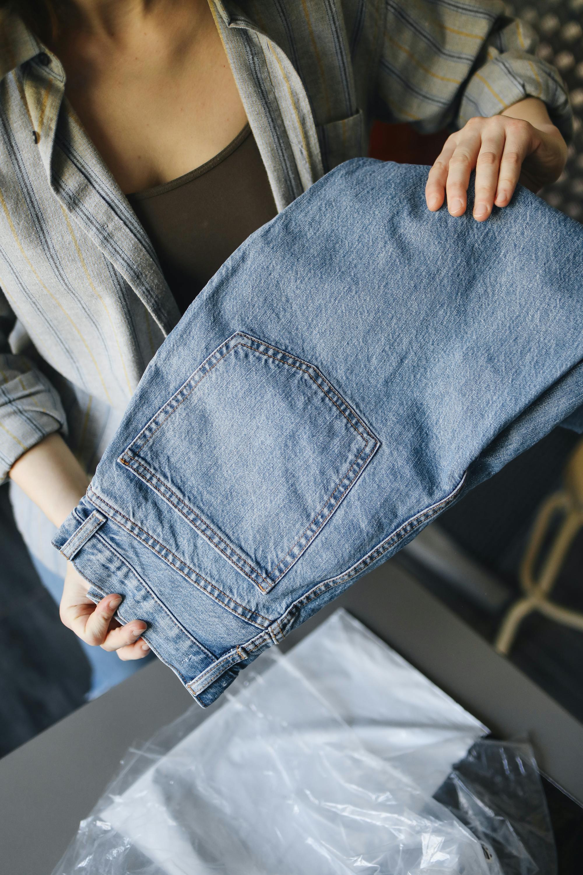 a woman holding a blue denim jeans