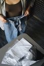 Woman in Blue Denim Jeans Sitting on Black Wooden Table