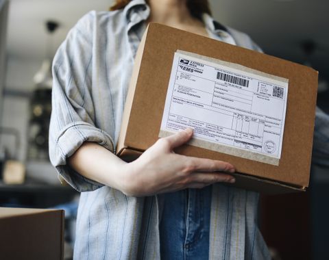 Mujer sosteniendo un paquete listo para enviar, venta online