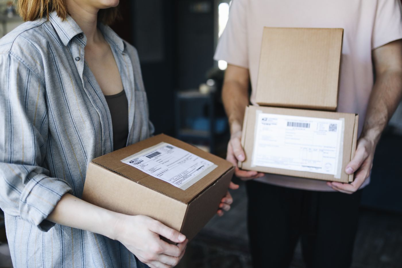 Two people carrying organized delivery boxes for an exchange process