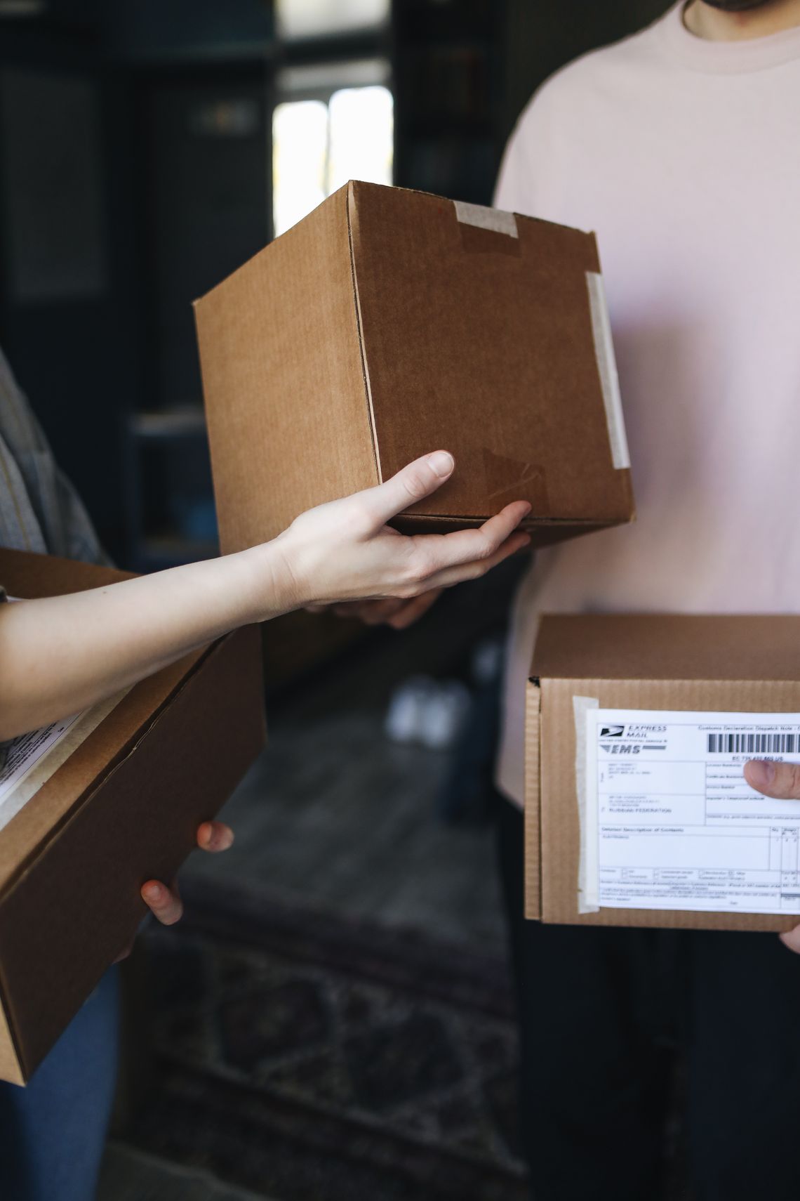 Hands exchanging a cardboard delivery package