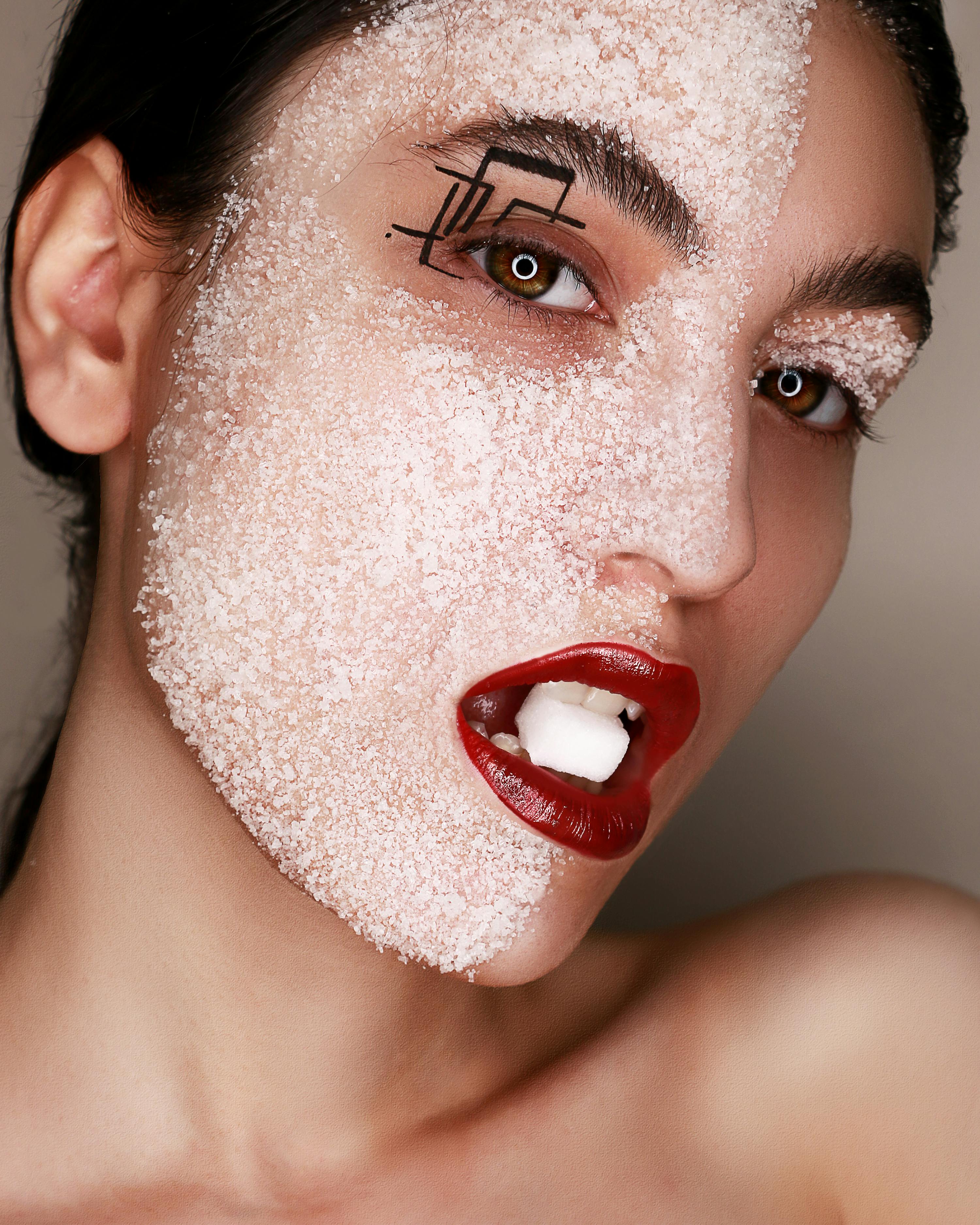 young woman with sugar on face and in mouth