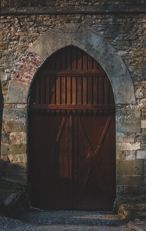 Free Arch Wooden Door on Stone Wall Stock Photo