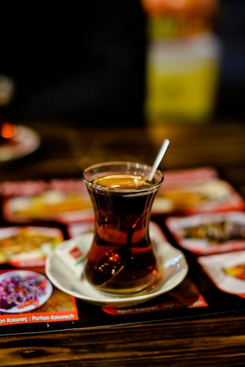 Tea in Middle East tea glass on ceramic plate plate on table in cafe