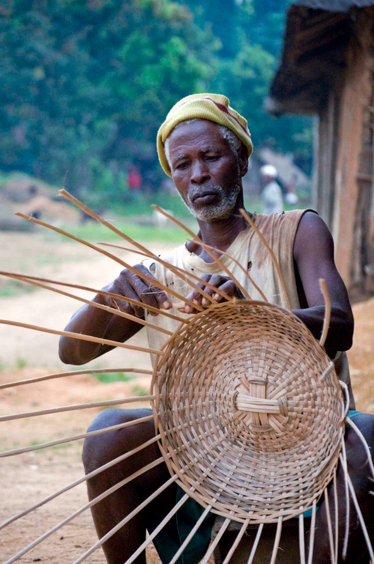 A Man Weaving A Basket