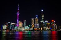 上海夜色中的天际线充满活力，以东方明珠塔和其多彩的倒影为特色