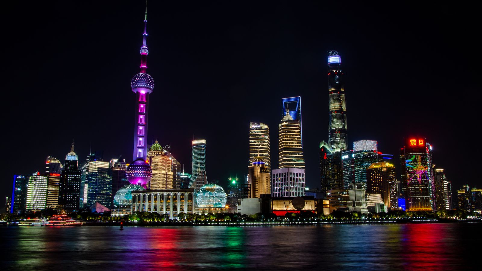 Skyline Shanghai dengan Oriental Pearl Tower dan gedung modern yang menyala pada malam hari