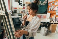 工作室里的女艺术家正在思考画布上的下一笔