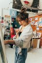 年轻的女艺术家正沉浸于绘画，在她那充满活力又略显凌乱的艺术工作室里