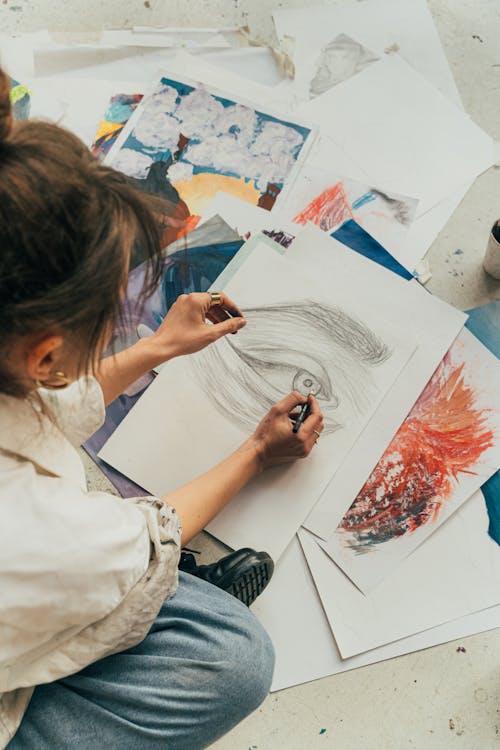 A Woman Drawing while Sitting on the Floor