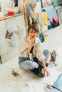 Woman in White Long Sleeve Shirt and Blue Denim Jeans Sitting on White Floor