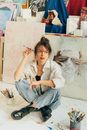 Woman in White Dress Shirt and Blue Denim Jeans Sitting on Floor